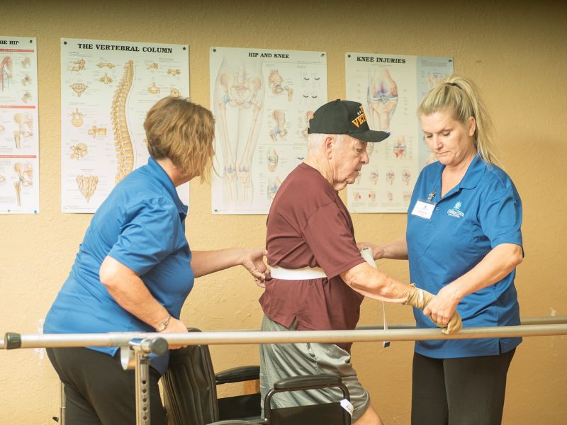 staff assisting the senior for physical therapy